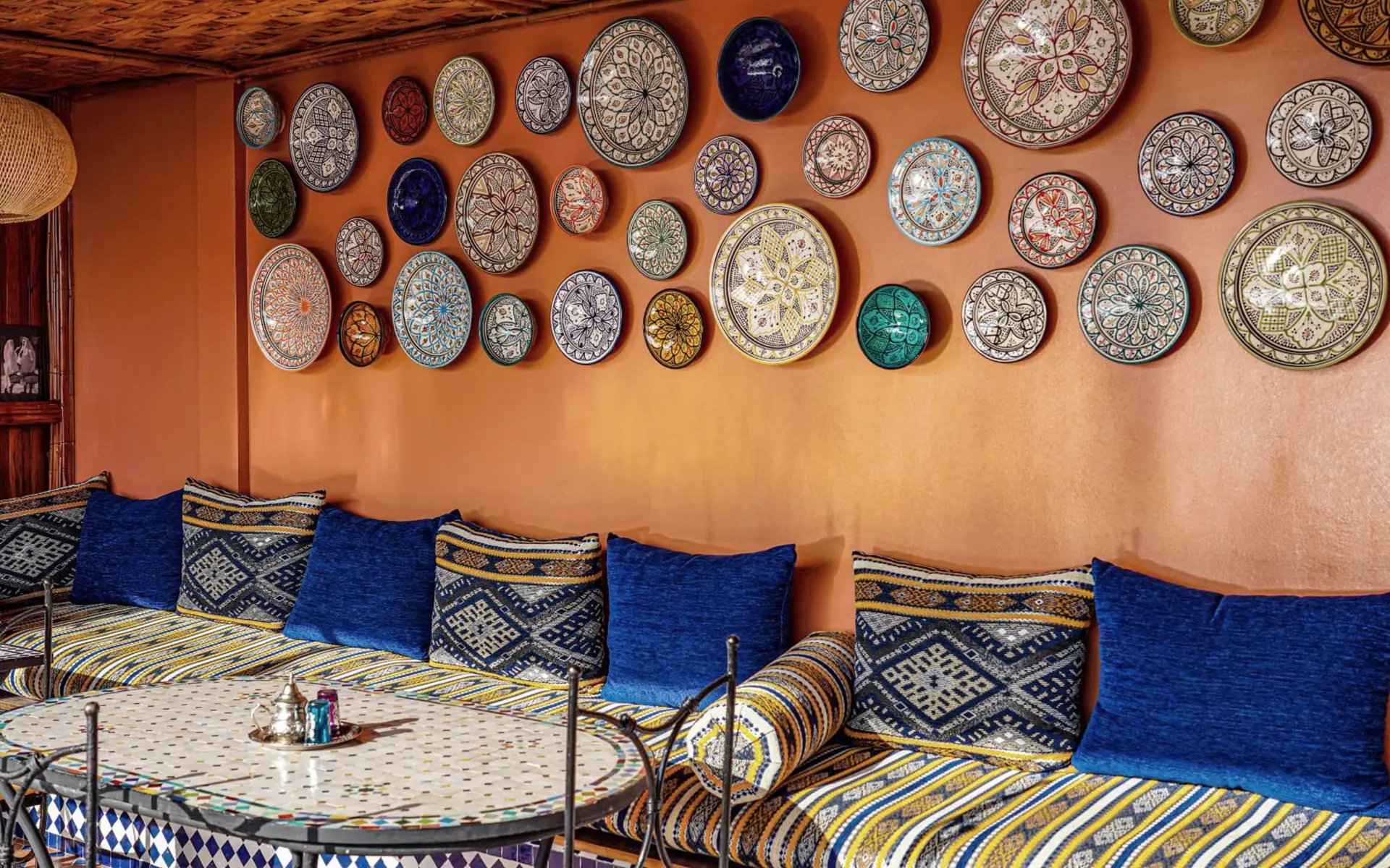 Le salon sur le toit, ses assiettes peintes et ses coussins bleus